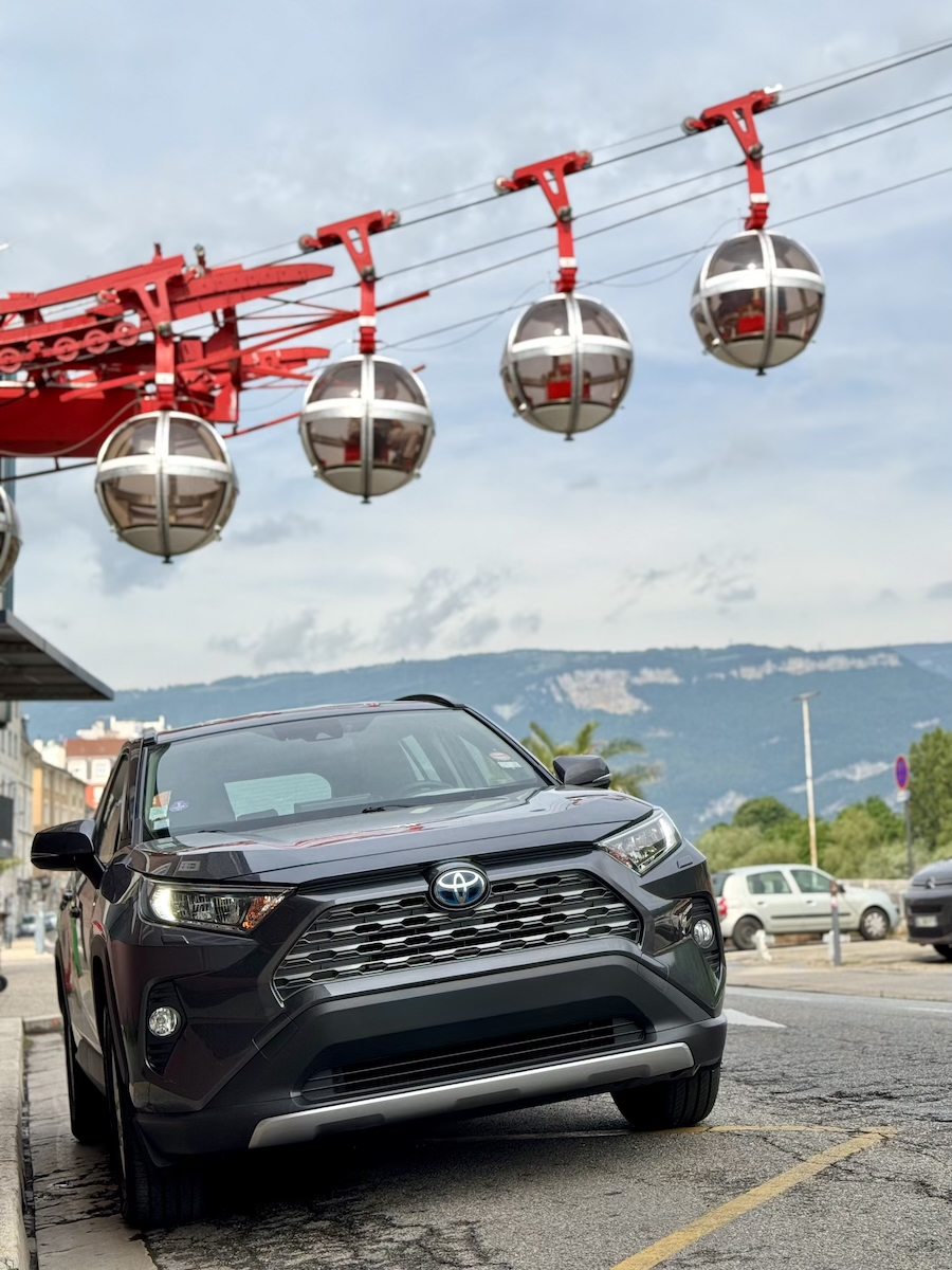 SUV Afranca Services stationné à Grenoble sous les bulles du téléphérique de la Bastille, illustrant un chauffeur privé VTC en ville.